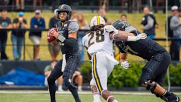 NASHVILLE, TENNESSEE - OCTOBER 19: Mo Hasan #18 of the Vanderbilt Commodores drops back to pass against Jatorian Hansford #28 of the Missouri Tigers during the first half at Vanderbilt Stadium on October 19, 2019 in Nashville, Tennessee. (Photo by Frederick Breedon/Getty Images)