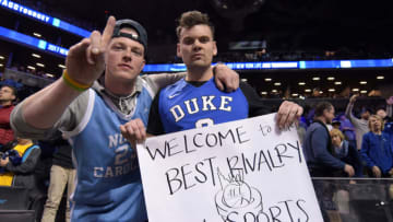 NEW YORK, NY - MARCH 10: A fan of the North Carolina Tar Heels (L) and the Duke Blue Devils pose for a photo while holding a sign referring to the Duke/UNC rivalry during the semifinals of the ACC Basketball Tournament at Barclays Center on March 10, 2017 in the Brooklyn borough of New York City. (Photo by Lance King/Getty Images)