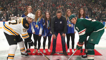 ST. PAUL, MN - MARCH 25: The 2018 U.S. Olympic Women's Ice Hockey Team takes part in a ceremonial puck drop along with Mikko Koivu #9 of the Minnesota Wild and Patrice Bergeron #37 of the Boston Bruins prior to the game at the Xcel Energy Center on March 25, 2018 in St. Paul, Minnesota. (Photo by Bruce Kluckhohn/NHLI via Getty Images)