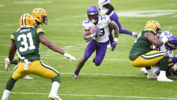 GREEN BAY, WISCONSIN - NOVEMBER 01: Dalvin Cook #33 of the Minnesota Vikings runs the ball as Aaron Jones #33 of the Green Bay Packers defends during the second quarter of the game at Lambeau Field on November 01, 2020 in Green Bay, Wisconsin. (Photo by Stacy Revere/Getty Images)