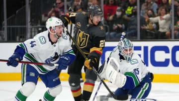 Nov 13, 2021; Las Vegas, Nevada, USA; Vancouver Canucks goaltender Thatcher Demko (35) defends his net as defenseman Kyle Burroughs (44) covers Vegas Golden Knights center Brett Howden (21) during the second period at T-Mobile Arena. Mandatory Credit: Stephen R. Sylvanie-USA TODAY Sports