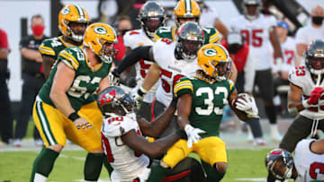 Oct 18, 2020; Tampa, Florida, USA; Green Bay Packers running back Aaron Jones (33) is tackled by Tampa Bay Buccaneers outside linebacker Jason Pierre-Paul (90) during the third quarter of a NFL game at Raymond James Stadium. Mandatory Credit: Kim Klement-USA TODAY Sports