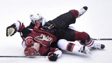 Jan 16, 2016; Glendale, AZ, USA; New Jersey Devils right wing Stephen Gionta (11) tackles Arizona Coyotes center Max Domi (16) during the third period at Gila River Arena. Mandatory Credit: Matt Kartozian-USA TODAY Sports