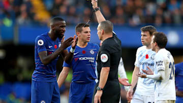 LONDON, ENGLAND - NOVEMBER 11: Match Referee Kevin Friend shows a yellow card to Antonio Ruediger of Chelsea during the Premier League match between Chelsea FC and Everton FC at Stamford Bridge on November 11, 2018 in London, United Kingdom. (Photo by Catherine Ivill/Getty Images)