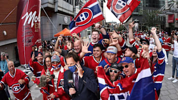 Jul 5, 2021; Montreal, Quebec, CAN; Montreal Canadiens fans cheer next to a journalist before game four of the 2021 Stanley Cup Final against the Tampa Bay Lightning at Bell Centre. Mandatory Credit: Jean-Yves Ahern-USA TODAY Sports