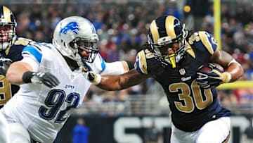 Dec 13, 2015; St. Louis, MO, USA; St. Louis Rams running back Todd Gurley (30) stiff arms Detroit Lions defensive tackle Haloti Ngata (92) during the second half at the Edward Jones Dome. The Rams defeated the Lions 21-14. Mandatory Credit: Jeff Curry-USA TODAY Sports