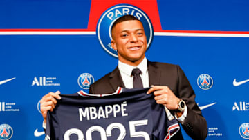 PARIS, FRANCE - MAY 23: Kylian Mbappe poses for photos with 2025 PSG t-shirt indicates his new contract during the Press Conference of Paris Saint-Germain at Parc des Princes on May 23, 2022 in Paris, France. (Photo by Antonio Borga/Eurasia Sport Images/Getty Images)