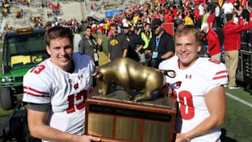 Oct 22, 2016; Iowa City, IA, USA; Wisconsin Badgers long snapper Connor Udelhoven (60) and Wisconsin Badgers quarterback Bart Houston (13) celebrate with the Heartland Trophy after their game with the Iowa Hawkeyes at Kinnick Stadium. The Badgers beat the Hawkeyes 17 to 9. Mandatory Credit: Reese Strickland-USA TODAY Sports