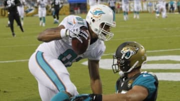 Aug 9, 2013; Jacksonville, FL, USA;Miami Dolphins tight end Dustin Keller (81) catches the ball for a touchdown as Jacksonville Jaguars free safety Chris Prosinski (42) attempted to defend during the first quarter at EverBank Field. Mandatory Credit: Kim Klement-USA TODAY Sports