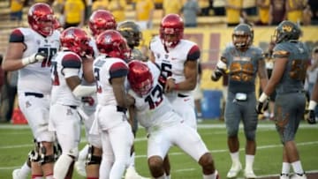 Nov 21, 2015; Tempe, AZ, USA; Arizona Wildcats quarterback Brandon Dawkins (13) is helped up by wide receiver Tyrell Johnson (2) and wide receiver Trey Griffey (5) during the fourth quarter of the territorial cup against the Arizona State Sun Devils at Sun Devil Stadium. The Sun Devils won 52-37. Mandatory Credit: Casey Sapio-USA TODAY Sports