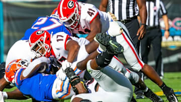 Georgia Bulldogs defensive lineman Jordan Davis (99) and Georgia Bulldogs linebacker Nakobe Dean (17) brings down Florida Gators running back Nay'Quan Wright (6). The Florida Gators played the Georgia Bulldogs in the first half Saturday afternoon, October 30, 2021 at TIAA Bank Field in Jacksonville, FL. [Doug Engle/Gainesville Sun]2021Flgai 103021 Bulldogsvsgators