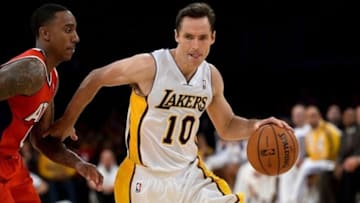 Nov 3, 2013; Los Angeles, CA, USA; Los Angeles Lakers point guard Steve Nash (10) drives around Atlanta Hawks point guard Jeff Teague (0) during the second half at Staples Center. Mandatory Credit: Robert Hanashiro-USA TODAY Sports