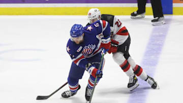 Rochester's Casey Fitzgerald carries the puck ahead of Ryan Schmelzer.