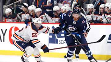 Sep 29, 2021; Winnipeg, Manitoba, CAN; Winnipeg Jets left wing Kyle Connor (81) shoots the puck against Edmonton Oilers center Luke Esposito (55) in the second period in the at Canada Life Centre. Mandatory Credit: James Carey Lauder-USA TODAY Sports
