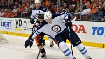Apr 5, 2016; Anaheim, CA, USA; Winnipeg Jets defenseman Jacob Trouba (8) anad Anaheim Ducks center Ryan Garbutt (16) battle for the puck in the first period during an NHL game at Honda Center. Mandatory Credit: Kirby Lee-USA TODAY Sports