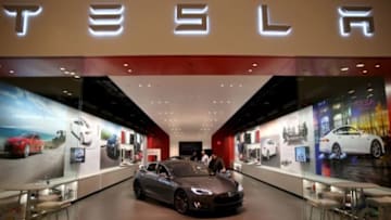 MIAMI, FL - FEBRUARY 19: People look at a Tesla Motors vehicle on the showroom floor at the Dadeland Mall on February 19, 2014 in Miami, Florida. Tesla said today it earned $46 million in the fourth quarter on a non-adjusted basis, or 33 cents a share, causing shares in the company to jump 12 percent. (Photo by Joe Raedle/Getty Images)