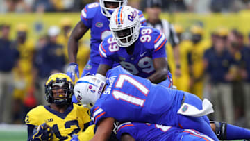 ARLINGTON, TX - SEPTEMBER 02: Chris Evans #12 of the Michigan Wolverines is tackled by Jordan Sherit #17 of the Florida Gators and Jachai Polite #99 of the Florida Gatorsin the first quarter of a game at AT&T Stadium on September 2, 2017 in Arlington, Texas. (Photo by Tom Pennington/Getty Images)