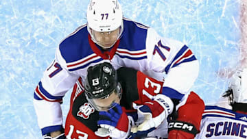 NEWARK, NEW JERSEY - APRIL 18: Nico Hischier #13 of the New Jersey Devils is held up by the New York Rangers during Game One in the First Round of the 2023 Stanley Cup Playoffs at the Prudential Center on April 18, 2023 in Newark, New Jersey. (Photo by Bruce Bennett/Getty Images)