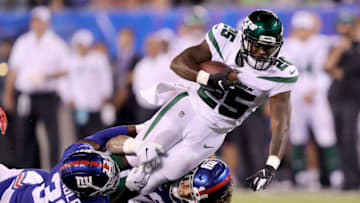 EAST RUTHERFORD, NEW JERSEY - AUGUST 08: Elijah McGuire #25 of the New York Jets carries the ball as Kenny Ladler #33 and Josiah Tauaefa #48 of the New York Giants defend in the fourth quarter during a preseason matchup at MetLife Stadium on August 08, 2019 in East Rutherford, New Jersey. (Photo by Elsa/Getty Images)
