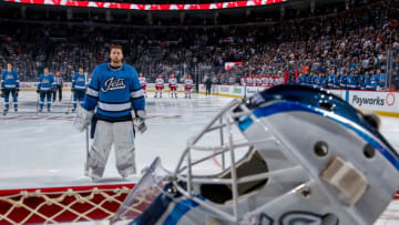 WINNIPEG, MB - OCTOBER 14: Goaltender Laurent Brossoit #30 of the Winnipeg Jets stands on the ice during the singing of 'O Canada' prior to puck drop against the Carolina Hurricanes at the Bell MTS Place on October 14, 2018 in Winnipeg, Manitoba, Canada. (Photo by Jonathan Kozub/NHLI via Getty Images)