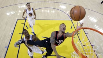 May 1, 2016; Oakland, CA, USA; Portland Trail Blazers guard Damian Lillard (0) shoots the basketball against Golden State Warriors forward Harrison Barnes (40) and guard Shaun Livingston (34) during the second half in game one of the second round of the NBA Playoffs at Oracle Arena. The Warriors defeated the Trail Blazers 118-106. Mandatory Credit: Marcio Jose Sanchez-Pool Photo via USA TODAY Sports
