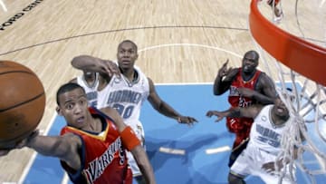 OKLAHOMA CITY - APRIL 5: Monta Ellis #8 of the Golden State Warriors shoots a layup against David West #30 of the New Orleans/Oklahoma City Hornets during a game on April 5, 2006 at the Ford Center in Oklahoma City, Oklahoma. NOTE TO USER: User expressly acknowledges and agrees that, by downloading and or using this photograph, user is consenting to the term and conditions of the Getty Images License Agreement. Mandatory Copyright Notice: Copyright 2006 NBAE (Photo by Layne Murdoch/NBAE via Getty Images)