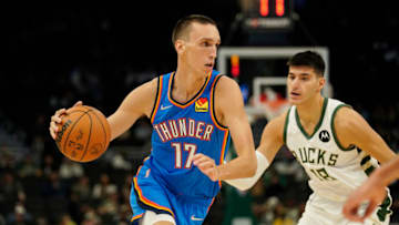 Aleksej Pokusevski #17 of the Oklahoma City Thunder dribbles the ball against Georgios Kalaitzakis #18 of the Milwaukee Bucks in the second half during a preseason game at Fiserv Forum on October 10, 2021 in Milwaukee, Wisconsin. NOTE TO USER: User expressly acknowledges and agrees that, by downloading and or using this photograph, user is consenting to the terms and conditions of the Getty Images License Agreement. (Photo by Patrick McDermott/Getty Images)