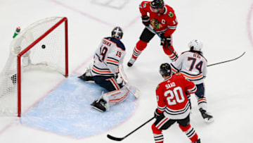 EDMONTON, ALBERTA - AUGUST 05: Jonathan Toews #19 and Brandon Saad #20 of the Chicago Blackhawks watch as a shot from teammate Connor Murphy (not pictured) gets past Mikko Koskinen #19 of the Edmonton Oilers for the go-ahead goal during the third period in Game Three of the Western Conference Qualification Round prior to the 2020 NHL Stanley Cup Playoffs at Rogers Place on August 05, 2020 in Edmonton, Alberta. (Photo by Jeff Vinnick/Getty Images)