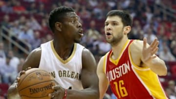 Dec 18, 2014; Houston, TX, USA; New Orleans Pelicans guard Jrue Holiday (11) shields the ball against the Houston Rockets forward Kostas Papanikolaou (16) at the Toyota Center. New Orleans Pelicans won 99 to 0. Mandatory Credit: Thomas B. Shea-USA TODAY Sports