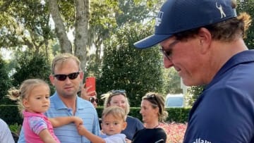 Phil Mickelson signs autographs for two young fans after his round of 67 on Saturday to take a two-shot lead in the Constellation Furyk & Friends, at the Timuquana Country Club.Phil Signing