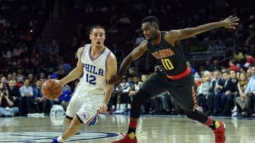 Jan 7, 2016; Philadelphia, PA, USA; Philadelphia 76ers guard T.J. McConnell (12) drives past Atlanta Hawks guard Tim Hardaway Jr. (10) during the second quarter of the game at Wells Fargo Center. Mandatory Credit: John Geliebter-USA TODAY Sports