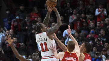 Feb 24, 2022; Chicago, Illinois, USA; Chicago Bulls forward DeMar DeRozan (11) scores against Atlanta Hawks center Clint Capela (15), left, Atlanta Hawks guard Kevin Huerter (3) and Atlanta Hawks guard Bogdan Bogdanovic (13) at the end of the second half at the United Center. Mandatory Credit: Matt Marton-USA TODAY