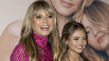 Heidi and Leni Klum smile on the red carpet in front of an enlarged photo from their Intimissimi campaign.