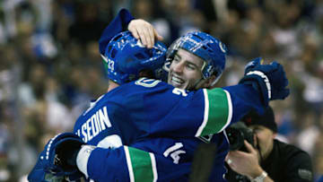 VANCOUVER, CANADA - APRIL 26: Alexandre Burrows #14 (right) of the Vancouver Canucks celebrates with Henrik Sedin #33 of the Vancouver Canucks after scoring the game winning goal against the Chicago Blackhawks during the overtime period in Game Seven of the Western Conference Quarterfinals during the 2011 NHL Stanley Cup Playoffs on April 26, 2011 at Rogers Arena in Vancouver, BC, Canada. The Canucks defeated the Blackhawks 2-1.(Photo by Rich Lam/Getty Images)