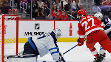 Oct 26, 2023; Detroit, Michigan, USA; Winnipeg Jets goaltender Connor Hellebuyck (37) makes the save on Detroit Red Wings center Michael Rasmussen (27) in the second period at Little Caesars Arena. Mandatory Credit: Rick Osentoski-USA TODAY Sports