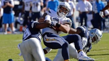 Sep 29, 2013; San Diego, CA, USA; San Diego Chargers running back Ryan Mathews (24) tries to push himself for more yards as he is hit by Dallas Cowboys inside linebacker Ernie Sims (59) and defensive end DeMarcus Ware (94) during second half action at Qualcomm Stadium. Mandatory Credit: Robert Hanashiro-USA TODAY Sports