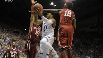 Jan 4, 2016; Lawrence, KS, USA; Kansas Jayhawks guard Frank Mason III (0) drives to the basket against Oklahoma Sooners guard Jordan Woodard (10) and forward Khadeem Lattin (12) in the second at Allen Fieldhouse. Kansas won the game 109-106 in triple overtime. Mandatory Credit: John Rieger-USA TODAY Sports