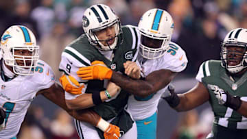 Dec 17, 2016; East Rutherford, NJ, USA; New York Jets quarterback Bryce Petty (9) is hit after throwing a pass by Miami Dolphins defensive end Andre Branch (50) during the first quarter at MetLife Stadium. Mandatory Credit: Brad Penner-USA TODAY Sports