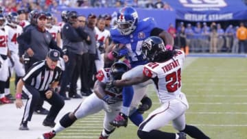 Oct 5, 2014; East Rutherford, NJ, USA; Atlanta Falcons linebacker Prince Shembo (53) and cornerback Desmond Trufant (21) tackle New York Giants running back Andre Williams (44) during the second half at MetLife Stadium. New York Giants defeat the Atlanta Falcons 30-20. Mandatory Credit: Jim O