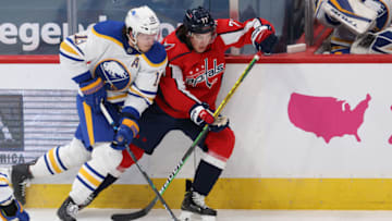 Feb 18, 2021; Washington, District of Columbia, USA; Buffalo Sabres defenseman Jake McCabe (19) and Washington Capitals right wing T.J. Oshie (77) battle for the puck in the first period at Capital One Arena. Mandatory Credit: Geoff Burke-USA TODAY Sports