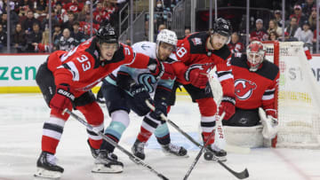 New Jersey Devils defenseman Ryan Graves (33) and New Jersey Devils defenseman Damon Severson (28) battle for the puck with Seattle Kraken center Alex Wennberg (21) during the first period at Prudential Center. Mandatory Credit: Ed Mulholland-USA TODAY Sports