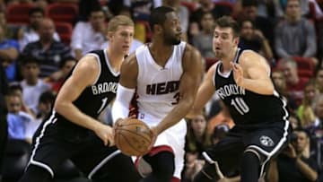 Jan 4, 2015; Miami, FL, USA; Miami Heat guard Dwyane Wade (3) is defended by Brooklyn Nets center Mason Plumlee (1) and guard Sergey Karasev (10) in the first half at American Airlines Arena. Mandatory Credit: Robert Mayer-USA TODAY Sports