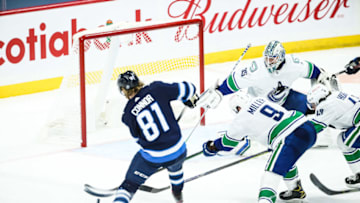 May 10, 2021; Winnipeg, Manitoba, CAN; Vancouver Canucks forward J.T. Miller (9) knocks the puck away from Winnipeg Jets forward Kyle Connor (81) during the third period at Bell MTS Place. Mandatory Credit: Terrence Lee-USA TODAY Sports