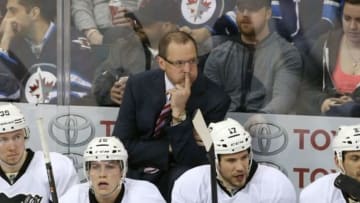 Apr 3, 2014; Winnipeg, Manitoba, CAN; Pittsburgh Penguins head coach Dan Bylsma reacts from behind the bench during the third period against the Winnipeg Jets at MTS Centre. The Penguins won 4-2. Mandatory Credit: Bruce Fedyck-USA TODAY Sports