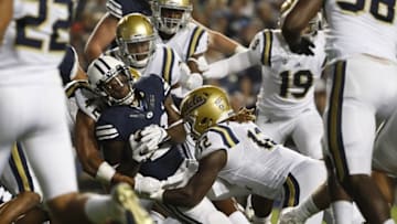 Sep 17, 2016; Provo, UT, USA; Brigham Young Cougars running back Jamaal Williams (21) is stopped by UCLA Bruins linebacker Kenny Young (42) and linebacker Jayon Brown (12) in the third quarter at Lavell Edwards Stadium. Mandatory Credit: Jeff Swinger-USA TODAY Sports