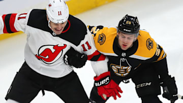 BOSTON - DECEMBER 27: Boston Bruins' Brandon Carlo holds on to the arm of the Devils' Brian Boyle as they chase a loose puck in the first period. The Boston Bruins host the New Jersey Devils in a regular season NHL hockey game at TD Garden in Boston on Dec. 27, 2018. (Photo by John Tlumacki/The Boston Globe via Getty Images)