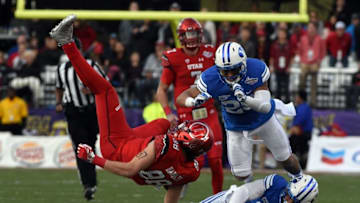 Dec 19, 2015; Las Vegas, NV, USA; Utah Utes tight end Harrison Handley (88) is tackled by Brigham Young Cougars defensive back Kai Nacua (12) and linebacker Teu Kautai (25) in the Las Vegas Bowl at Sam Boyd Stadium. Utah defeated BYU 35-28. Mandatory Credit: Kirby Lee-USA TODAY Sports