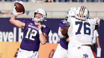 Auburn footballJan 1, 2021; Orlando, FL, USA; Northwestern Wildcats quarterback Peyton Ramsey (12) throws a pass as Northwestern Wildcats offensive lineman Ethan Wiederkehr (76) blocks Auburn Tigers defensive tackle Jeremiah Wright (76) during the second half at Camping World Stadium. Mandatory Credit: Reinhold Matay-USA TODAY Sports