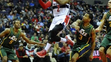 Dec 14, 2014; Washington, DC, USA; Washington Wizards guard John Wall (2) drives the basket as Utah Jazz guard Rodney Hood (5) and Utah Jazz guard Trey Burke (3) look on during the second half at Verizon Center. The Wizards won 93-84. Mandatory Credit: Brad Mills-USA TODAY Sports