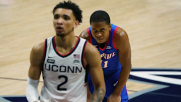 Dec 30, 2020; Storrs, Connecticut, USA; DePaul Blue Demons guard Charlie Moore (11) looks on as Connecticut Huskies guard James Bouknight (2) shoots a free-throw in the second half at Harry A. Gampel Pavilion. Mandatory Credit: David Butler II-USA TODAY Sports